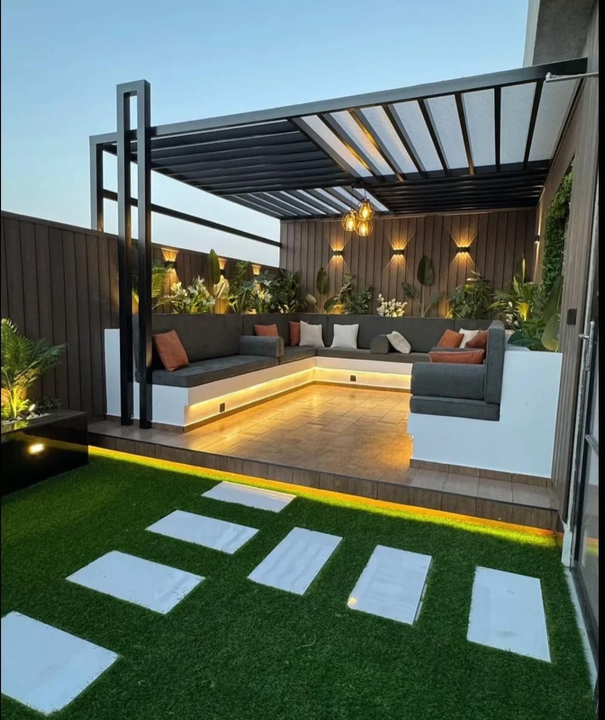 A Zanzibar hotel garden lounge with a timber pergola and soft evening lighting