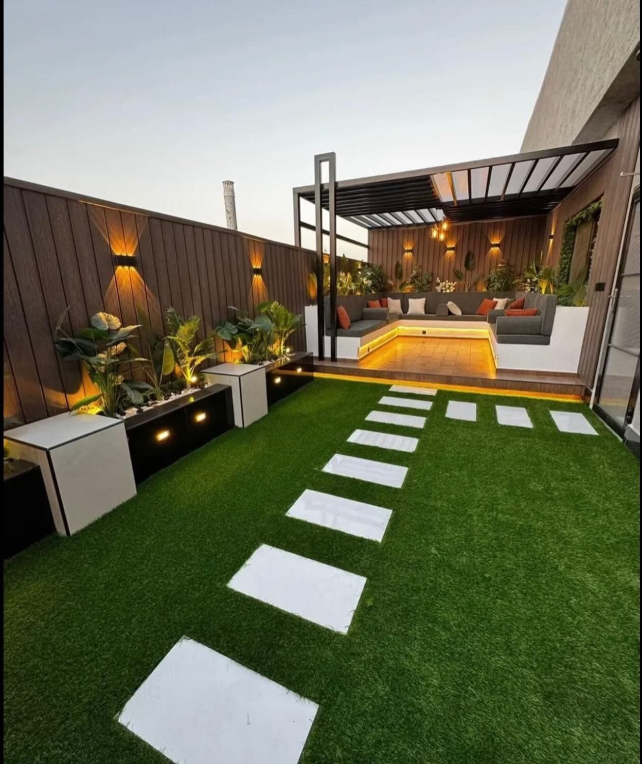 Wide view through a landscaped hotel courtyard toward the outdoor lounge